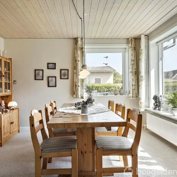 Et spisebord med seks stole står i et lyst rum. Bordet er dækket med en dug. Et vitrineskab fuld af nipsgenstande ses til venstre. Store vinduer giver udsigt til en have.