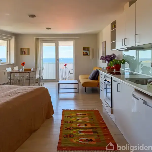 Et rundt bord med en blomstervase, bog, krus og solbriller står på en balkon med udsigt over havet og en bygning med tårn i baggrunden.