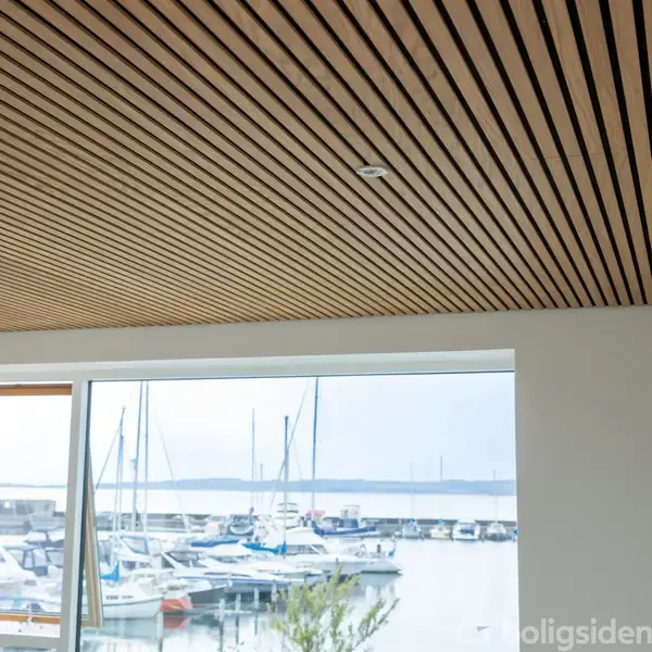 Træloft med indbyggede lys, delvist åbent vindue med udsigt over en marina med både, mod en baggrund af vand og en horisontlinje.