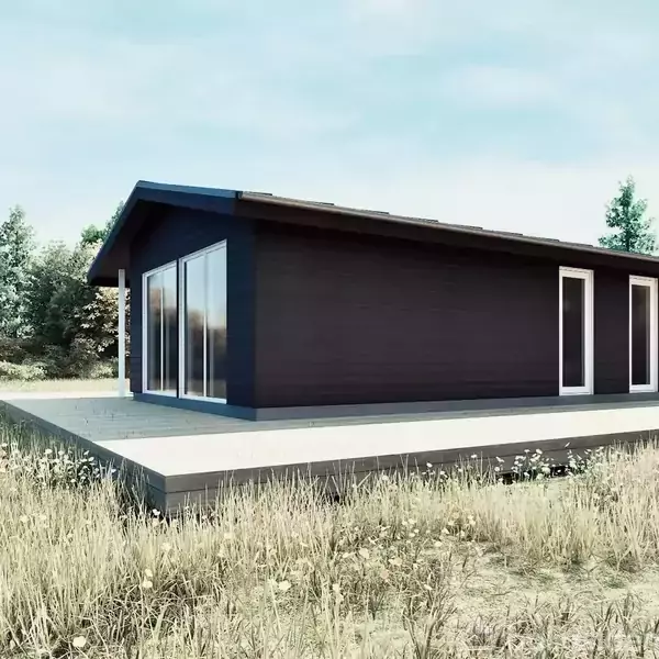 En sort hytte står stille på en græsbevokset grund. Sollys reflekterer fra store vinduer, mens træer omringer området i baggrunden.