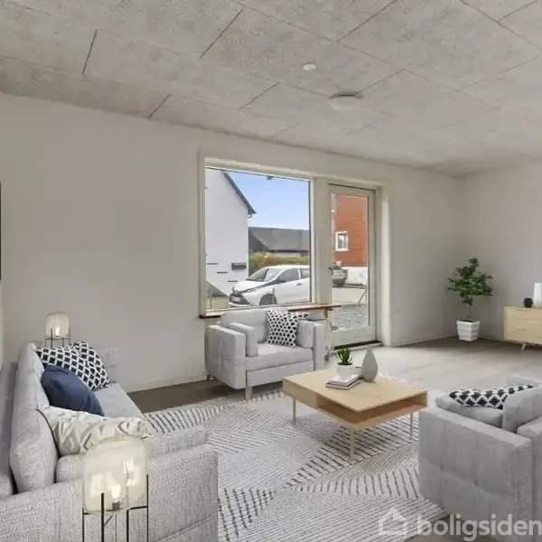 En lys stue indeholder en grå sofa, to lænestole, et sofabord og et TV på en skænk. Udenfor ses biler og et rødt hus gennem det store vindue.