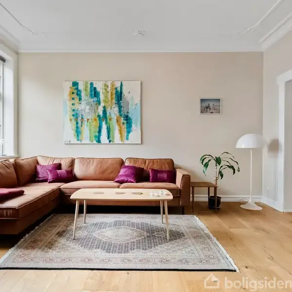 Brun lædersofa med lilla puder står foran et stort vindue. Maleri og lille billede på væggen. Træbord og tæppe på gulvet i en lys stue.