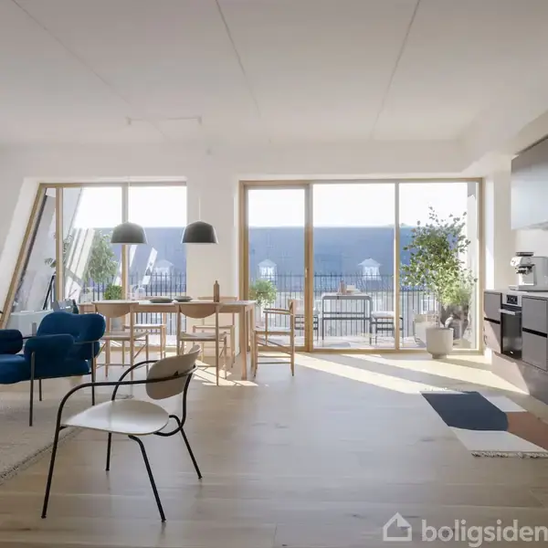 Stue med moderne møblering; blå stole, sort-hvid stol, spisebord og planter. Store vinduer slipper lys ind, afslører balkon med udsigt over tage. Køkkenet har mørke skabe og hvidevarer.