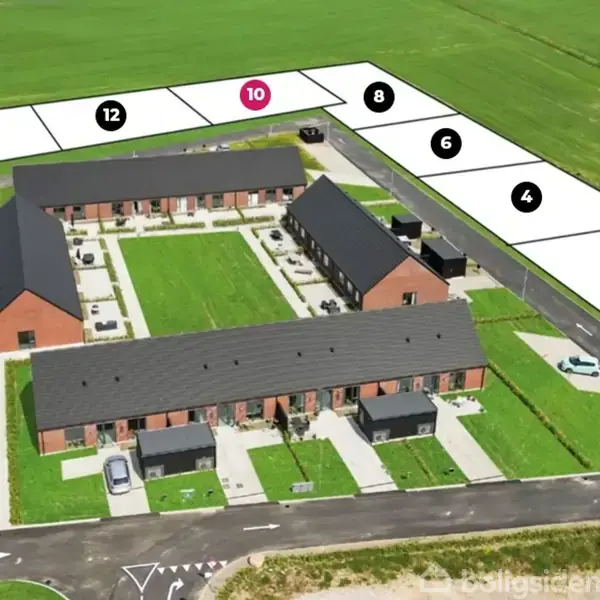 Et boligkompleks med flere rækkehuse omkring grønne fællesområder. Tilstødende er numre markeret på tomme parceller: 14, 12, 10, 8, 6, 4, 2, indikerende ledig grund. Omgivet af marker.