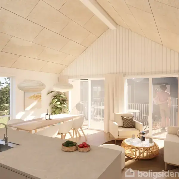 Køkken-alrum med sofa og spisebord i lys og moderne indretning. Store vinduer og skydedøre giver udsigt til balkon og natur. Frugt på køkkenø understreger det indbydende miljø.