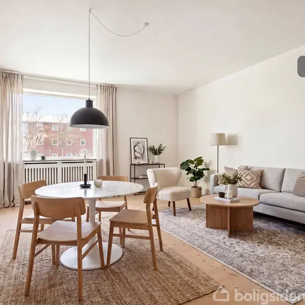 Stue med et rundt spisebord og fire træstole placeret på et tæppe. Sofa med sofabord til højre. Store vinduer giver lys. Tekst: "Visualisering".