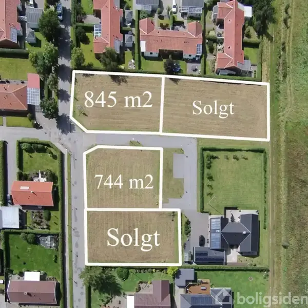 To byggrunde markeret som "Solgt," en på 845 m2 og en på 744 m2, ligger blandt bebyggelse i et boligområde.