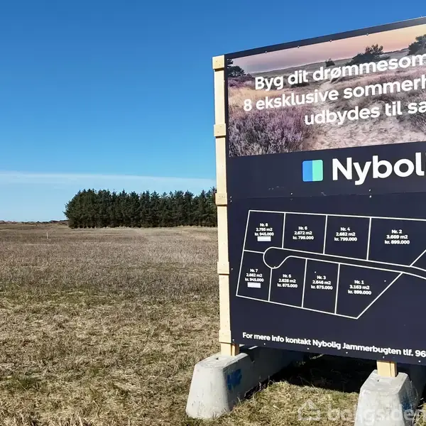 Et stort skilt viser sommerhusgrunde til salg fra Nybolig på en åben mark. Teksten inkluderer: "Byg dit drømmesommerhus! 8 eksklusive sommerhusgrunde udbydes til salg" og "Priser er inkl. tilslutningsafgifter".