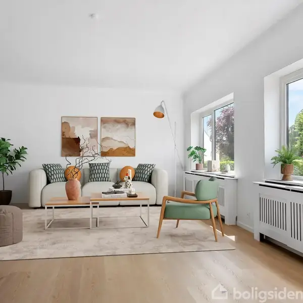 Stue med lys indretning. En sofa og stol placeret på et tæppe, omkranset af planter og kunstværker. Store vinduer giver udsigt til en grøn have.