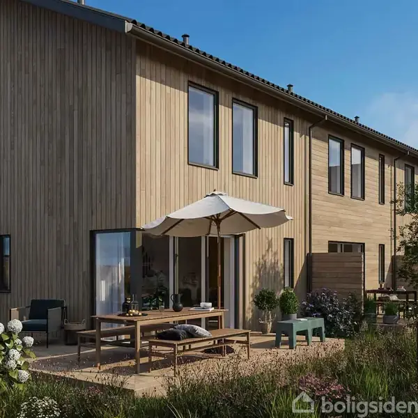 Skandinavisk stil træhus med store vinduer. Terrasse møbleret med træbord, stole og parasol. Omgivet af have med blomster og grussti, beliggende under blå himmel.