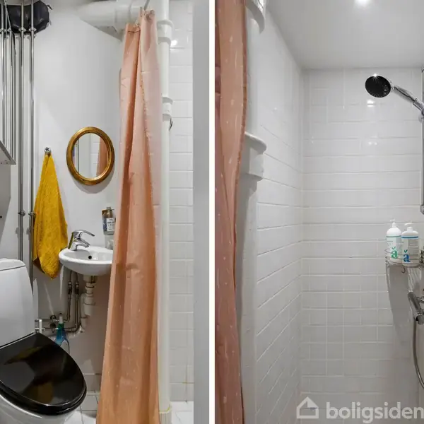 Et lille badeværelse med en toiletstol, spejl og håndvask. En bruser med lyserød forhæng ses til højre, omgivet af hvide fliser og badeprodukter på en holder.