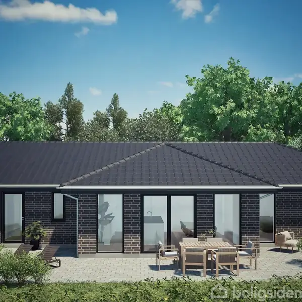 Et moderne hus med sort tag og store vinduer står omgivet af grønne træer. På terrassen foran huset er der havemøbler.