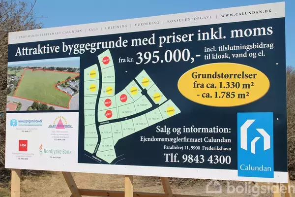 Reklameskilt viser byggegrunde til salg. Tekst: "Attraktive byggegrunde med priser inkl. moms fra kr. 395.000,- Grundstørrelser fra ca. 1.330 m² - ca. 1.785 m²." Kontaktinformation til Ejendomsmæglerfirmaet Calundan.