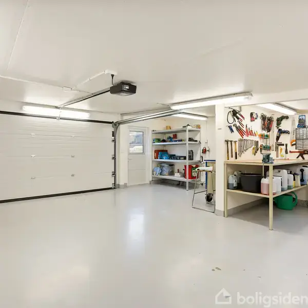 Garage med arbejdsbord fyldt med værktøj, hylder med malerbøtter, og åbne døre skaber en lys og ryddelig arbejdsplads. Væggene har flere ophæng med redskaber.