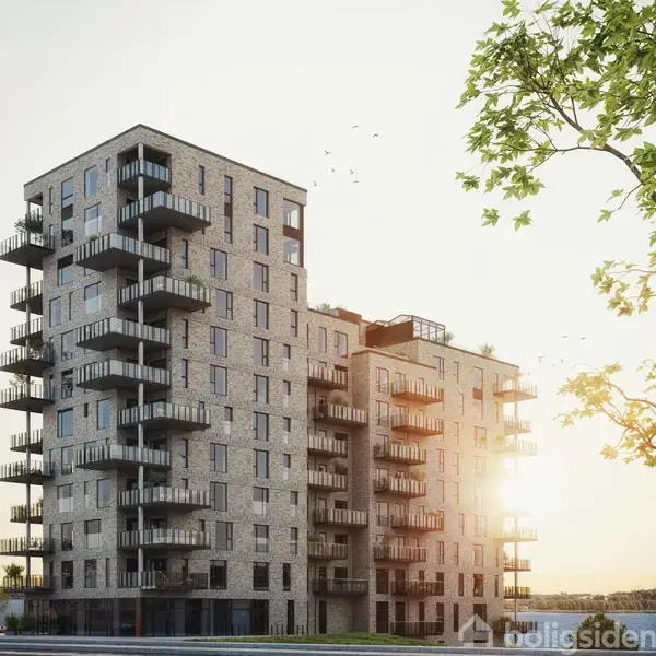 Et moderne lejlighedskompleks med altaner, står stille i sollys. Omgivet af grønne træer og en lys himmel, skaber bygningen en urban, men naturlig atmosfære.