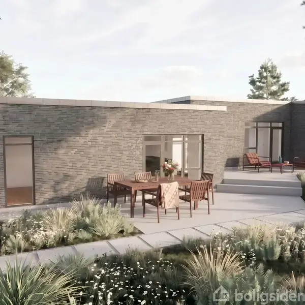 En moderne, lav murstensbygning med store vinduer. En person står ved en busk. En terrasse i forgrunden er omgivet af havemøbler og frodig beplantning under en klar himmel.