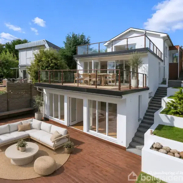 Stor moderne villa med to etager har en rummelig terrasse med udendørs møbler i en frodig have. Hvide vægge og store vinduer giver et lyst og åbent miljø.