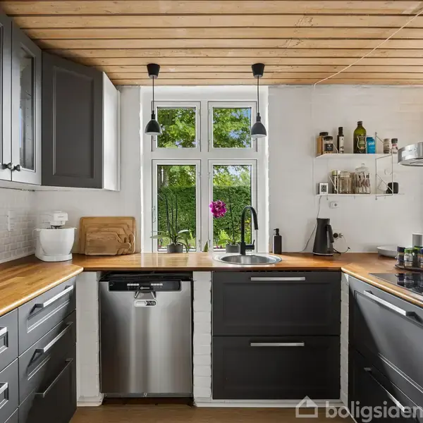 Et moderne køkken med træloft og hvide vægge. Mørkegrå skabe og en træbordplade omkranser en vask. Der står glas og flasker på hylderne, og et vindue viser udsigt til grønne træer.