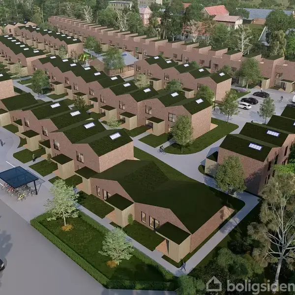 Rækkehuse med flade, grønne tage står ordnet i rækker. Biler og mennesker ses langs vejen. Området er omgivet af træer, hvilket skaber en urban boligudvikling midt i naturen.