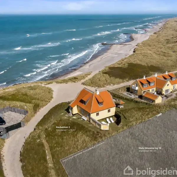 Hus med orange tag står ved kysten, tæt på havet. Omkringliggende områder består af andre huse og omfattende klitlandskab. Tekst: "Krakbakken 2", "Niels Onneksvej 10", "Grundejer ve, gr-70".