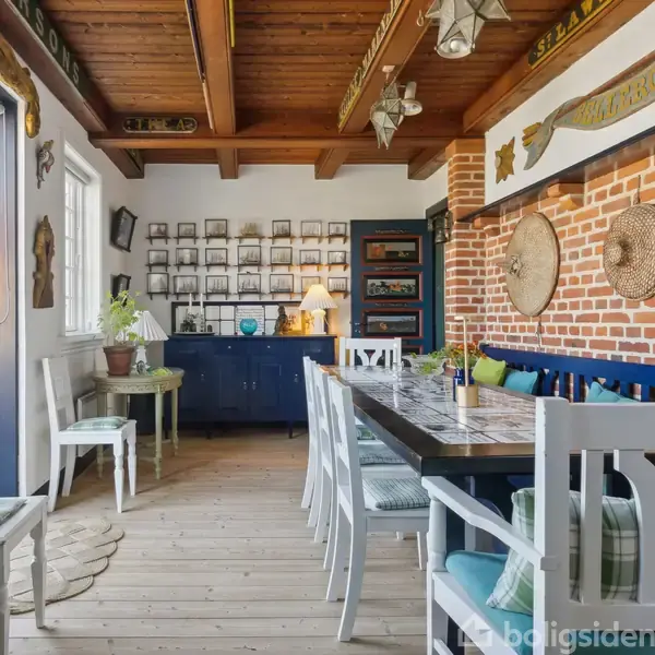 Spisebord omgivet af hvide stole står nær en murstensvæg med dekorative elementer. Flasker og lamper hænger fra loftet. Et blåt skab og lys står ved væggen, og der er åbne døre til en terrasse.