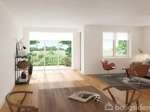 Træbord med stole ligger i en lys stue, hvor store vinduer åbner ud mod en grøn udsigt. En sofa og lænestole står ved et tæppe i hjørnet, med planter og lamper omkring.