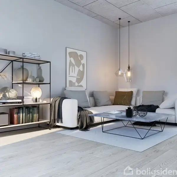 Sofa står i stuehjørne, omgivet af hylder med bøger og dekoration. Et sofabord er placeret foran, med hængende lamper over. Sollys strømmer gennem et vindue med gardiner.