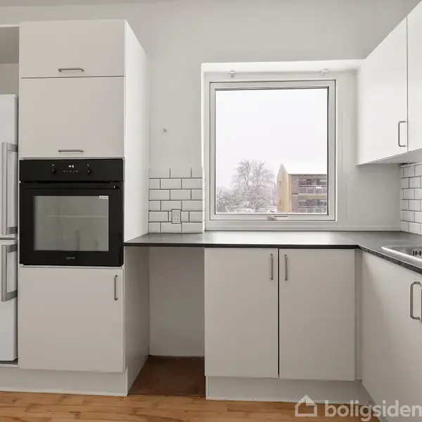 Et moderne køkken med hvide skabe og skuffer har en indbygget ovn og køleskab. Bordpladen er mørk, der er et vindue med udsigt til sne dække udenfor, og væggene har hvide fliser.