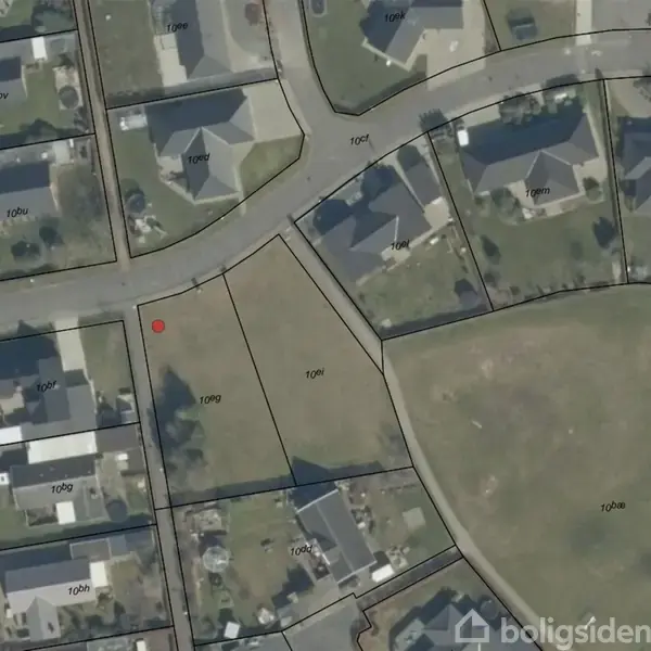 Satellitbillede med grundplaner, hvor en tom grund markeret som "10gi" befinder sig mellem parcelhuse. Grunden er omkranset af veje og markeret med en rød prik til venstre.