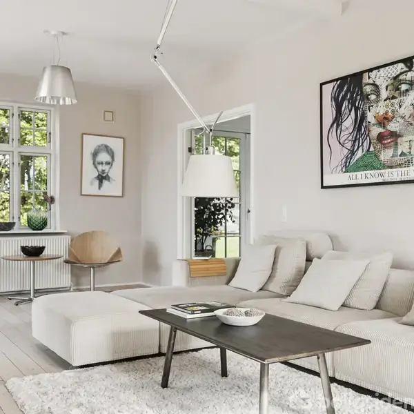 En lys stue med en beige sofa, sofabord og moderne kunst på væggen. Stuen har store vinduer og minimalistisk indretning. Tekst på billedet: "ALL I KNOW IS THE WAY I FEEL".