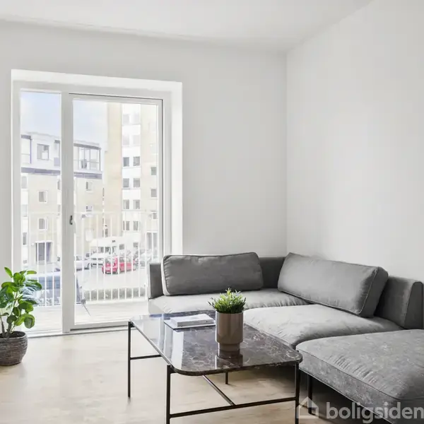 Grå vinkelsofa står i stue ved glasdør; sofabord med plante ovenpå; udenfor ses bygninger og parkering. En grøn plante står ved siden af døren på trægulv.