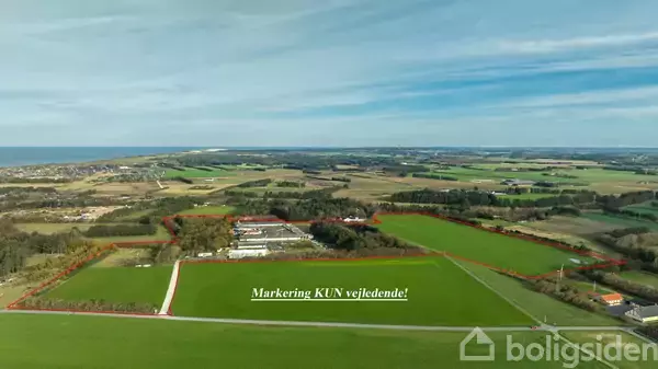 Grønt landbrugsområde omgivet af røde markeringslinjer, set fra luften under en blå himmel. Tekst: "Markering KUN vejledende!"