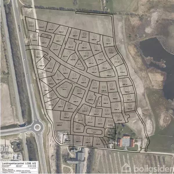 Kort viser et planlagt boligområde med opdelte grunde og veje i et landligt miljø, omkranset af marker og vandløb. Nederst er en rundkørsel, og der er tekst i nederste venstre hjørne.