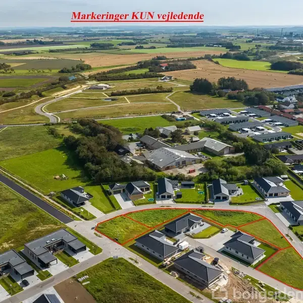 Et boligområde ses fra luften, med flere huse omkranset af græsarealer. Røde linjer markerer grunde. Teksten øverst siger: "Markeringer KUN vejledende". Udsigten strækker sig til åbne marker i baggrunden.