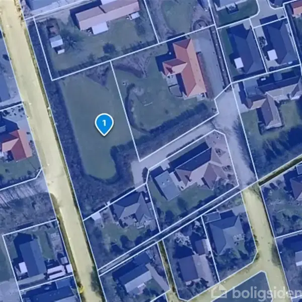 Et kortudsnit viser et boligområde med huse, veje og haver omgivet af grønne områder. En blå markør med tallet "1" er placeret i centrum, indikerende en bestemt lokation.