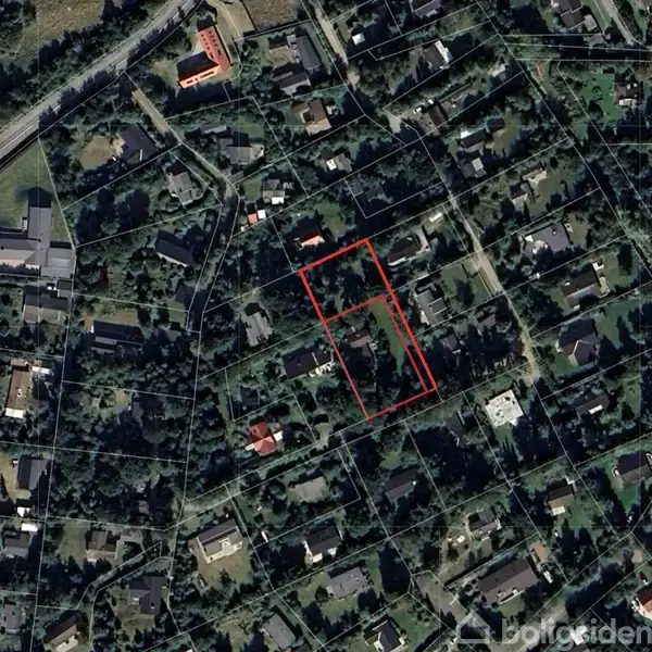Parcel markeret med rød linje midt i beboelsesområde, omgivet af huse og grønne områder. Veje omkranser området, der ligger i en tættere bebygget forstad.