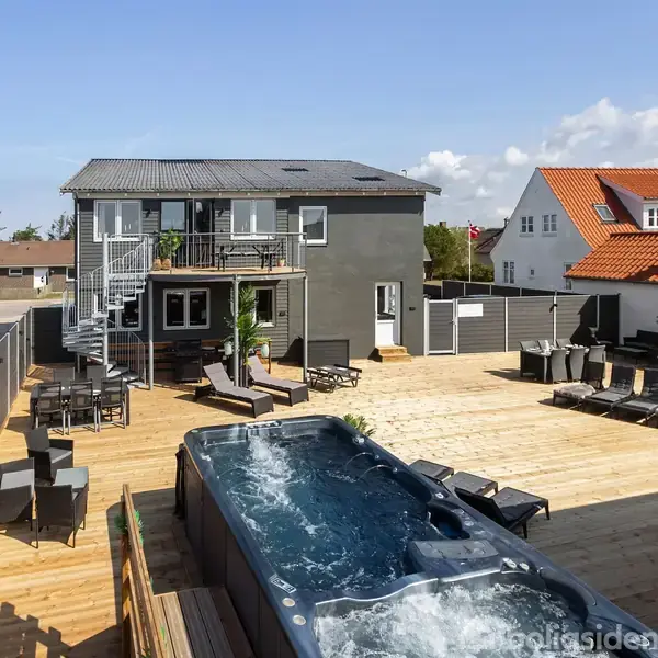 Udendørs boblebad ses i forgrunden af en rummelig terrasse, der omgiver et moderne hus med en tagterrasse og spiraltrappe i en solrig beboelsesområde.