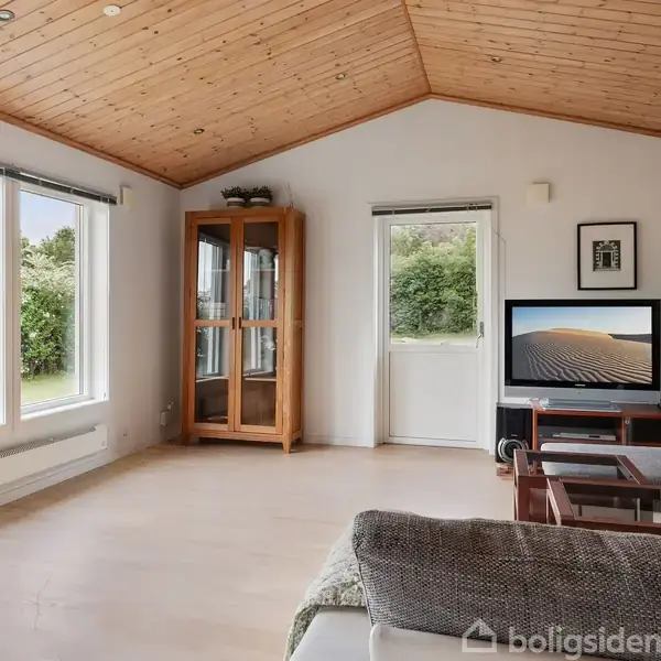 Stue med sofa og sofabord, fjernsyn tændt med naturmotiv, stor glasvitrine til venstre. Lyse trægulve og loft. Store vinduer til venstre, udsigt til grøn have.