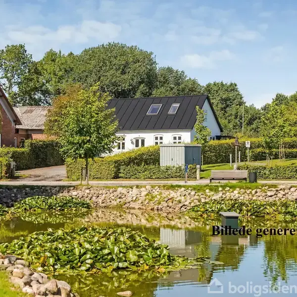 Hvidt hus med sort tag står stille ved en smuk dam omkranset af grønne træer og sten. Tekst: "Billede genereret med AI".