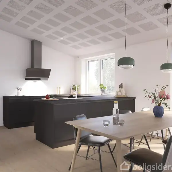 Køkkenbord med sort skab under og moderne emhætte, står i et lyst køkken med træbordsmøbler, blomster i vase, og udsigt til vindueslys og minimalistisk indretning.