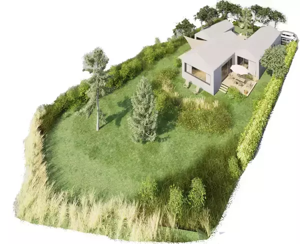 Et moderne hus med fladt tag står på en græsplæne omgivet af træer og buske. Der er en terrasse med stole, og en indkørsel med en parkeret bil.