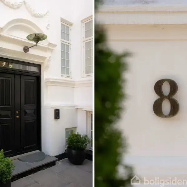 En sort dør står åben med to planter foran i en bygning med hvide vægge og vinduer. Til højre vises tallet "8" på væggen.