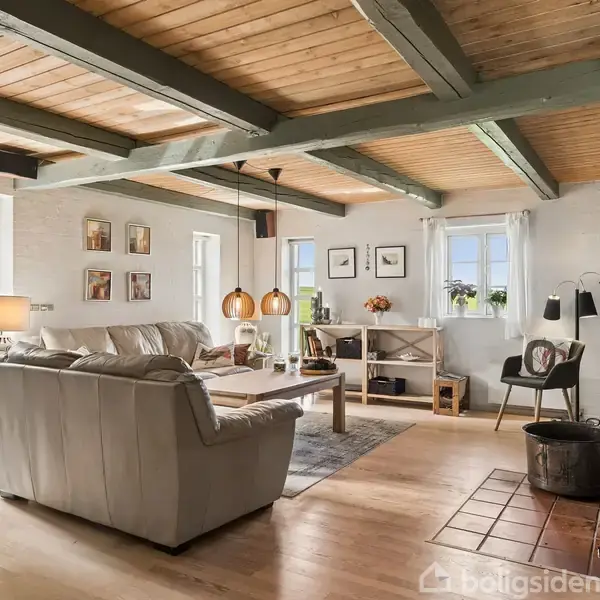 Et hvidt hus med brune tegltag er omgivet af grønne træer. Nummeret "19" ses på facaden. Til venstre er der en carport med flisebelagt indkørsel.