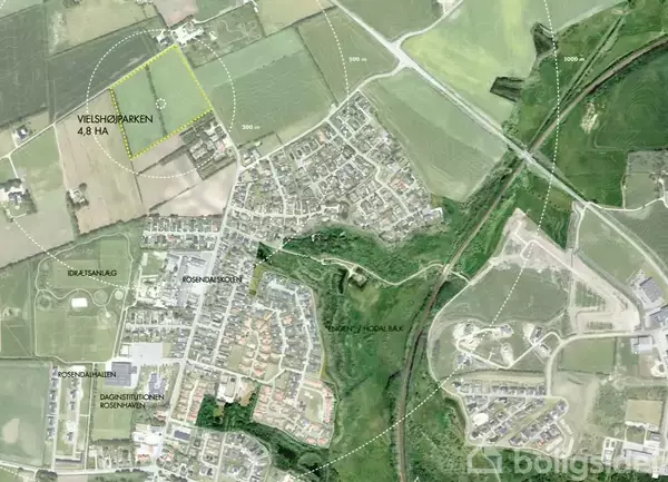 Luftfoto viser et veletableret boligområde med veje og marker omkring. Tekst viser steder som "VEJSHOPARKEN 4,8 HA", "ROSENHØJ SKOLE", "DAGINSTITUTIONEN ROSENVANG", "ROSNÆSHOLM LOKAL BAK" og "IDRÆTSANLÆG".