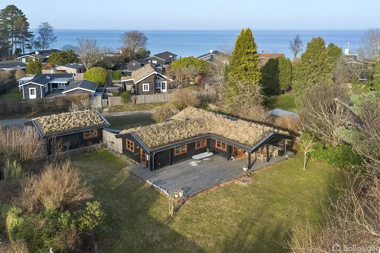 Unikt sommerhus på vandsiden med sedumtag, stor naturgrund og privat strandsti.