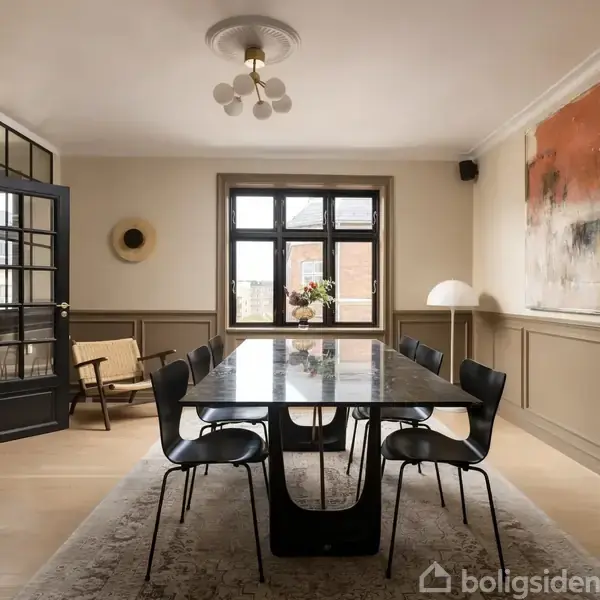 Et langt spisebord med otte sorte stole er centralt placeret i et elegant spisestueinteriør. Rummet har lyskilder, et stort vindue og en abstrakt vægmaleri.