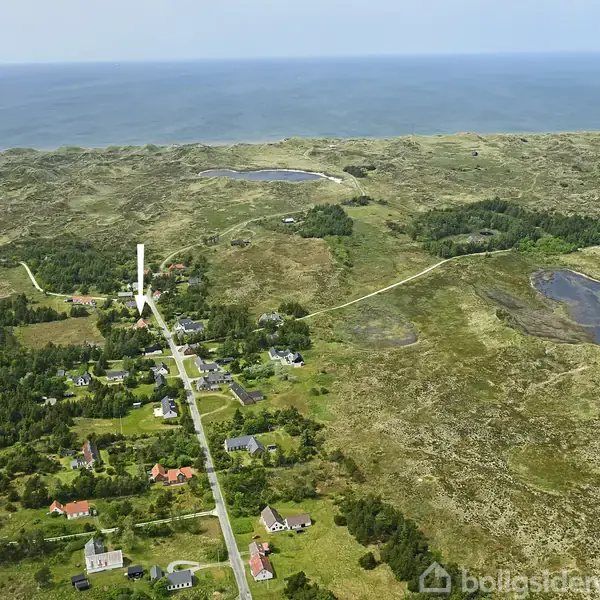 Landsbyhuse ligger spredt mellem grønne marker og skove, mens veje forbinder dem. I baggrunden ses havet og kuperede landskaber.