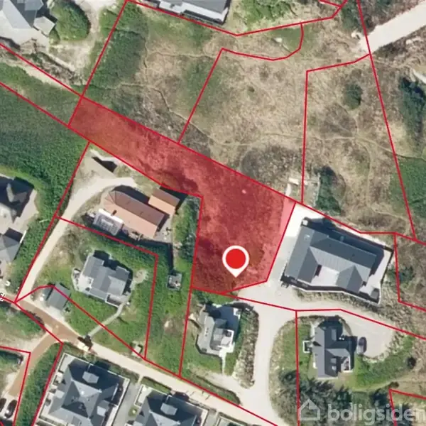 Et kort viser et boligområde med flere huse, hvor et bestemt område er markeret med rød farve. En hvid cirkel fremhæver et punkt inden i det røde område.