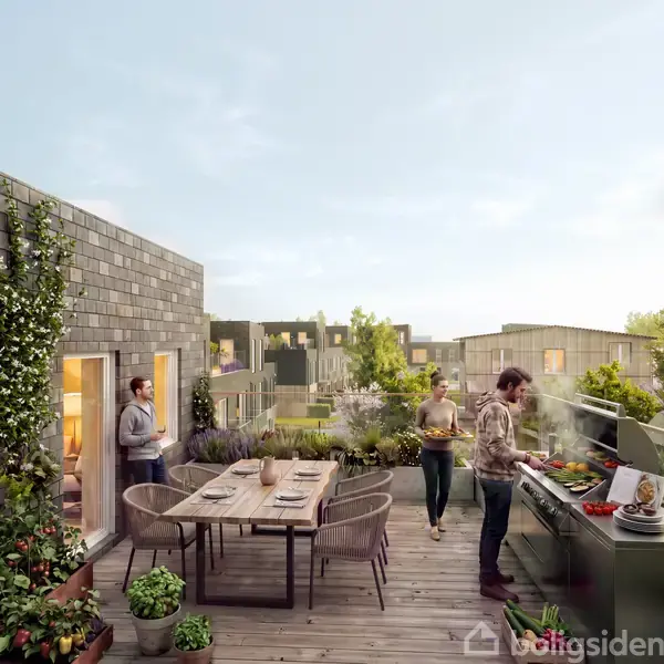 En terrasse med to personer laver mad på en grill. En tredje person står nær døren. Der er et bord med stole og planter omkring. Moderne boligblokke ses i baggrunden.