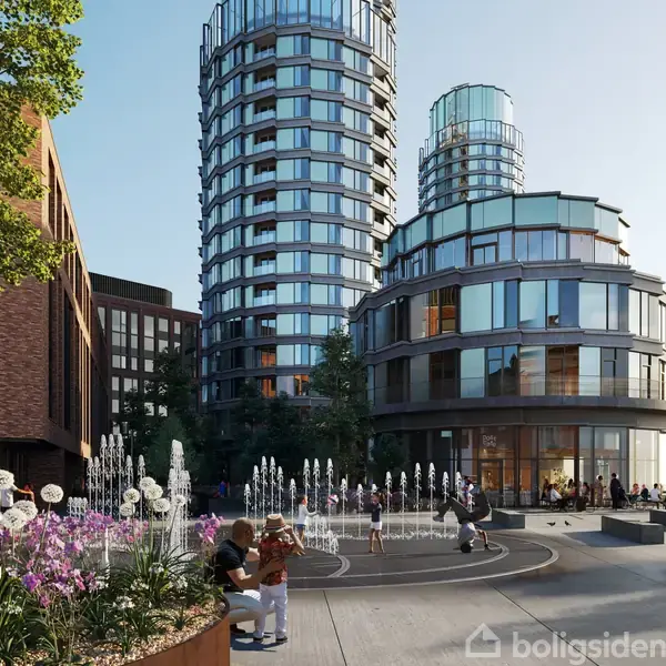 Runde, moderne bygninger dominerer bybilledet, omgivet af springvand og blomsterbede foran. Folk sidder og går rundt i et åbent torv med sollys reflekterende i glasfacaderne.